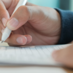 picutre of a female hand holding a pen to fill out an application form