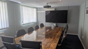 large meeting room for 12 people with large feature resin board room table chairs and large screen