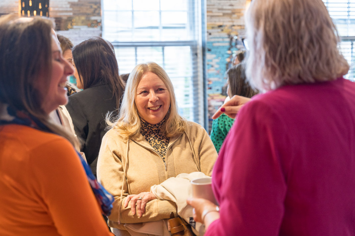 3 ladies chatting and laughing at a networking event