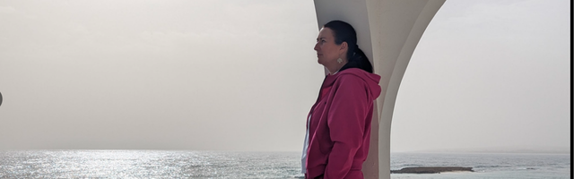 Sharon looking to the side overlooking the sea on a gloomy day